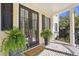 Inviting front porch with double doors, ferns, and brick flooring and columns at 2440 Cat Tail Pond Rd, Seabrook Island, SC 29455