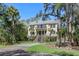 Beautiful home with grand front entrance and upper balcony nestled among mature trees at 2440 Cat Tail Pond Rd, Seabrook Island, SC 29455