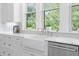 Bright kitchen with white cabinets, farmhouse sink, marble countertop, and stainless steel appliances at 2440 Cat Tail Pond Rd, Seabrook Island, SC 29455