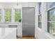 Modern kitchen with stainless steel refrigerator, white cabinets, and bright natural light from windows at 2440 Cat Tail Pond Rd, Seabrook Island, SC 29455