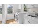 Clean laundry room with modern washer and dryer, white cabinets, and a marble countertop sink at 2440 Cat Tail Pond Rd, Seabrook Island, SC 29455