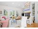 Bright living room with fireplace, built-in shelving, and french doors to the outdoors at 2440 Cat Tail Pond Rd, Seabrook Island, SC 29455
