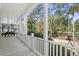 Inviting porch featuring a spacious seating area with views of the lush lawn, mature palms, and surrounding landscape at 2440 Cat Tail Pond Rd, Seabrook Island, SC 29455
