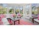 Inviting sunroom with floor-to-ceiling windows, comfortable seating, and bright, colorful decor at 2440 Cat Tail Pond Rd, Seabrook Island, SC 29455