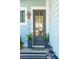 Stylish front door with glass pane, flanked by planters and a lantern style sconce at 2545 Hatch Dr, Johns Island, SC 29455