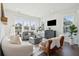 Sun-drenched living room with hardwood floors, large windows, and stylish modern furniture at 2545 Hatch Dr, Johns Island, SC 29455
