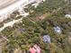 Aerial view displays property's layout and beach access with walkways through lush landscape at 263 Pelican Flight Dr, 15.4% Share, Dewees Island, SC 29451