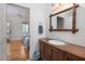 Bathroom vanity featuring a bamboo framed mirror and view into bedroom with two twin beds and wood floors at 263 Pelican Flight Dr, 15.4% Share, Dewees Island, SC 29451