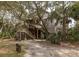 Exterior shot of a charming home with wooden siding, lush greenery, and a rustic staircase at 263 Pelican Flight Dr, 15.4% Share, Dewees Island, SC 29451