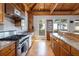 Kitchen with stainless steel range, granite countertops, wood cabinets, and stained glass windows at 263 Pelican Flight Dr, 15.4% Share, Dewees Island, SC 29451