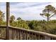 An ocean view beyond a wooden deck and a line of lush tropical trees and vegetation at 263 Pelican Flight Dr, 15.4% Share, Dewees Island, SC 29451
