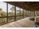 A screened porch with wood flooring and views of lush greenery at 263 Pelican Flight Dr, 15.4% Share, Dewees Island, SC 29451