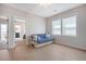 Bright bedroom with a blue futon, wood floors, and natural light coming in from a window at 2739 Calico Bass Ln, Johns Island, SC 29455