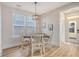 Cozy dining area with a wood table, four chairs, and a chandelier, bathed in natural light from a nearby window at 2739 Calico Bass Ln, Johns Island, SC 29455