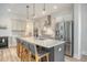 Open kitchen with island seating, stainless steel appliances, and modern white cabinets at 2739 Calico Bass Ln, Johns Island, SC 29455