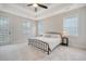 Spacious main bedroom featuring a wrought iron bed, plush carpeting, a ceiling fan, and plenty of natural light at 2739 Calico Bass Ln, Johns Island, SC 29455