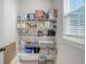 Organized pantry shelves filled with various household items, illuminated by natural light from a nearby window at 2739 Calico Bass Ln, Johns Island, SC 29455