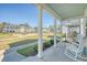Inviting front porch with rocking chairs overlooks a shared lawn area and attractive neighborhood homes at 2739 Calico Bass Ln, Johns Island, SC 29455