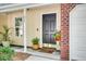 Close-up of a welcoming front door with red brick and plants to create an inviting entryway at 275 Kelsey Blvd, Charleston, SC 29492