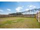 Spacious fenced backyard featuring lush grass and a scenic view of a treeline and pond at 284 Shadybrook Dr, Summerville, SC 29486