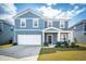 Charming two-story home with blue siding, a well-manicured lawn, and an attached two-car garage at 284 Shadybrook Dr, Summerville, SC 29486