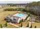 Aerial view of a community pool with a clubhouse and playground surrounded by lush landscaping and mature trees at 284 Shadybrook Dr, Summerville, SC 29486