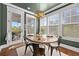 Cozy dining space with a round wooden table, chandelier, and many bright windows to the outside at 306 Long Pier St, Summerville, SC 29486