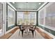 Bright dining area with a wooden table, chandelier, many windows, and green-painted walls at 306 Long Pier St, Summerville, SC 29486