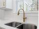 Stylish kitchen sink with a modern golden faucet, white backsplash and bright natural light at 306 Long Pier St, Summerville, SC 29486