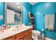 Well-lit bathroom features a vanity, mirror, and coordinated decor against vibrant turquoise walls at 3075 Old Highway 52, Moncks Corner, SC 29461