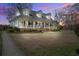 Inviting home exterior with a classic front porch and lush green lawn at sunset at 318 Archibald Dr, Goose Creek, SC 29445