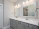 Bright bathroom featuring double sinks with modern lighting and a door leading to another area at 332 Dahlia Row Dr, Summerville, SC 29486
