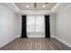Bright bedroom featuring wood floors, shiplap wall, trey ceiling and large windows with black curtains at 332 Dahlia Row Dr, Summerville, SC 29486