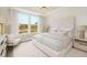 Serene bedroom featuring large windows, a tray ceiling, and elegant neutral decor at 332 Dahlia Row Dr, Summerville, SC 29486
