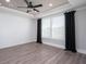 An empty bedroom with a ceiling fan, wood floors, shiplap wall and large windows at 332 Dahlia Row Dr, Summerville, SC 29486