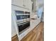 Modern kitchen featuring stainless steel appliances and white cabinetry, double oven, and beautiful wood floors at 3522 Habenaria Rd, Mount Pleasant, SC 29466