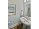Stylish powder room featuring a pedestal sink, wall art, and hardwood floors at 3522 Habenaria Rd, Mount Pleasant, SC 29466