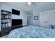A well-lit bedroom featuring a bed with patterned bedding, TV, and a large bookcase at 3537 Sewel Ave, Mount Pleasant, SC 29466