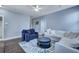 A bright living area features a cozy blue armchair, white couch, and a patterned rug on hardwood floors at 3537 Sewel Ave, Mount Pleasant, SC 29466