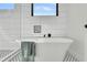 Close-up of bathtub with a towel draped over it with a large window and intricate tile inset above at 4036 Azalea Farms Way, McClellanville, SC 29458