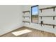 A bedroom with custom shelves, hardwood floors, and a large window that allows for lots of natural light at 4036 Azalea Farms Way, McClellanville, SC 29458