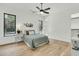 Well-lit bedroom featuring light hardwood floors, stylish decor, and large windows offering outdoor views at 4036 Azalea Farms Way, McClellanville, SC 29458