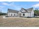 Front elevation featuring modern farmhouse design with wood porte-cochere, landscaping, and brick walkway at 4036 Azalea Farms Way, McClellanville, SC 29458