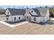Front elevation featuring modern farmhouse design with wood porte-cochere, landscaping, and brick walkway at 4036 Azalea Farms Way, McClellanville, SC 29458