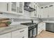 Modern kitchen featuring a black range, hood, and sleek white cabinetry at 4036 Azalea Farms Way, McClellanville, SC 29458