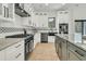 Stylish kitchen with white cabinetry, gray countertops, and a black range hood at 4036 Azalea Farms Way, McClellanville, SC 29458