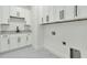 Well-lit laundry room features ample white cabinets, black-and-white tile flooring, and marble countertops at 4036 Azalea Farms Way, McClellanville, SC 29458