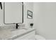 A modern half-bath with a marble countertop, black faucet, and simple decor at 4036 Azalea Farms Way, McClellanville, SC 29458