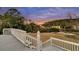 Relaxing backyard view from a deck, showcasing natural landscapes with tall trees, a grassy field, and stairs at 4051 Colonel Vanderhorst Cir, Mount Pleasant, SC 29466