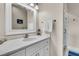 White bathroom features a marble countertop vanity, ample lighting and a walk-in shower at 4051 Colonel Vanderhorst Cir, Mount Pleasant, SC 29466